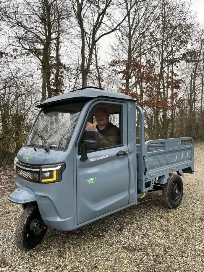 Grå LuxCap kabinescooter med lad parkeret på skovvej