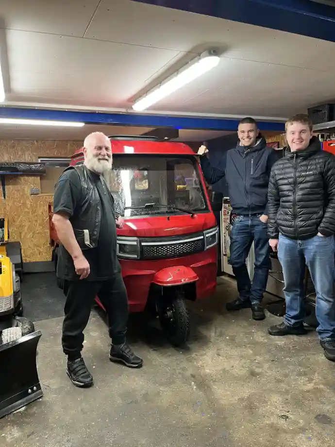 Fremvisning af rød elektrisk kabinescooter i opvarmet garage