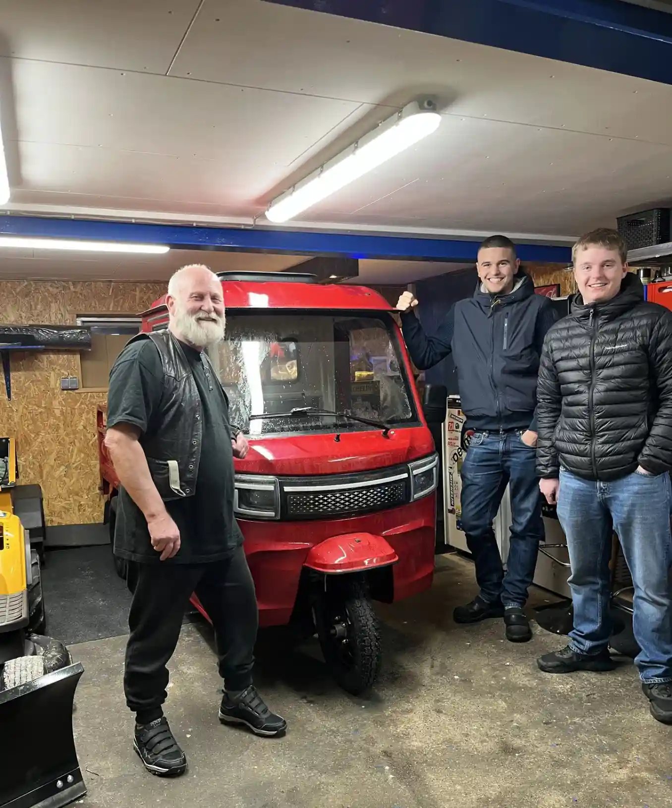 Fremvisning af rød elektrisk kabinescooter i opvarmet garage